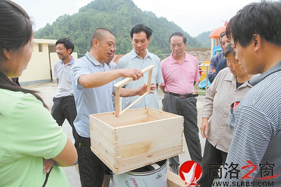 下崗職工寧啟林經(jīng)過工會培訓(xùn)成為養(yǎng)蜂能手，圖為他在給基層養(yǎng)蜂戶傳授經(jīng)驗。