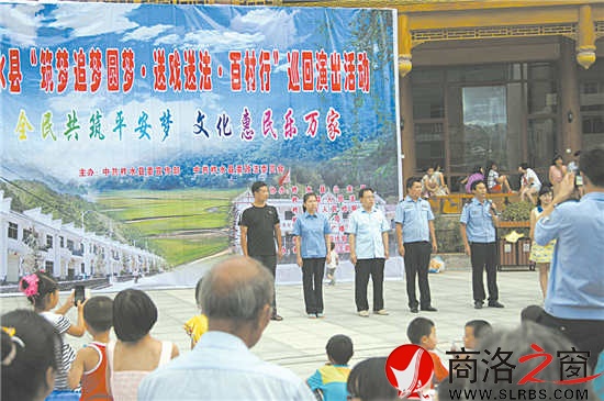 圖為柞水縣“送法送戲百村行”活動中“三官一律”上臺與群眾進(jìn)行互動現(xiàn)場